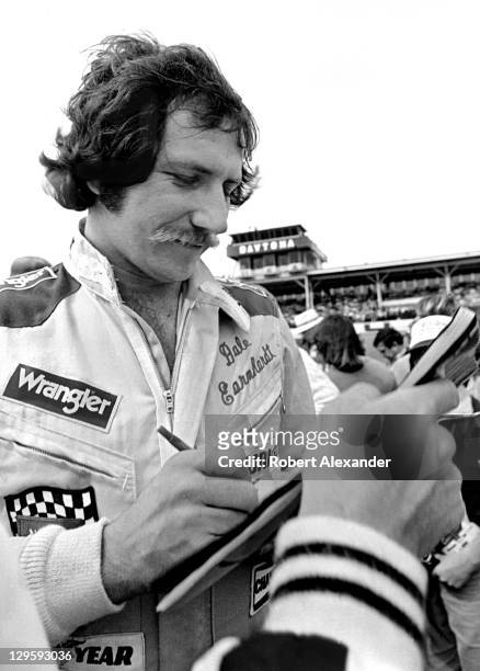 Driver Dale Earnhardt Sr. Signs autographs in the infield at the Daytona International Speedway prior to drivers' introductions and the start of the...