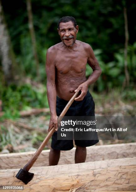 Man carving a canoe in the forest, Milne Bay Province, Alotau, Papua New Guinea on October 3, 2009 in Alotau, Papua New Guinea.