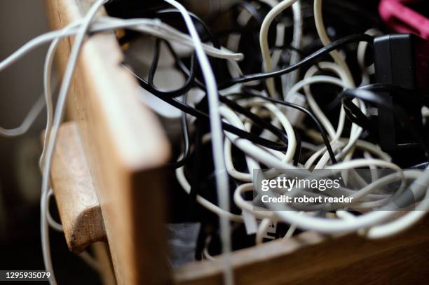 tangled messy computer cables in a drawer - chargeur de batterie photos et images de collection