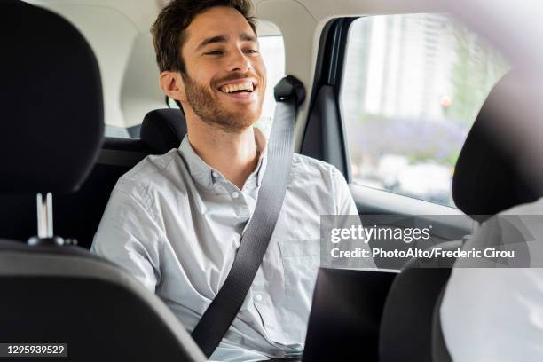 young man travelling by taxi - seat belt stock pictures, royalty-free photos & images