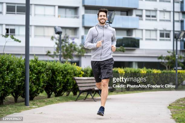 young man jogging in park - jogging photos et images de collection