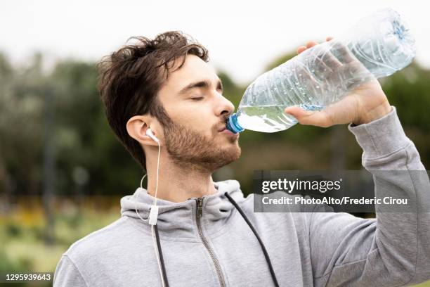 young man drinking water - man drinking water photos et images de collection