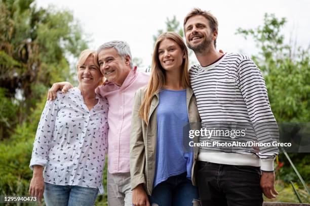 happy family standing together - schoondochter stockfoto's en -beelden