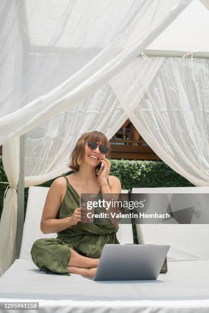happy woman talking on smart phone at laptop in cabana - coconut water isolated stock pictures, royalty-free photos & images