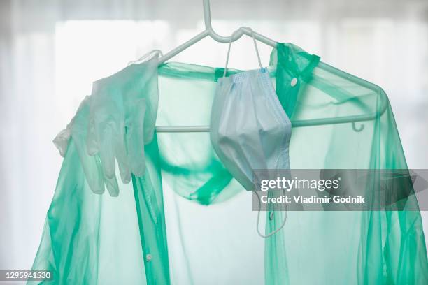 protective suit, gloves and face mask hanging on hanger - mono blanco traje protector fotografías e imágenes de stock