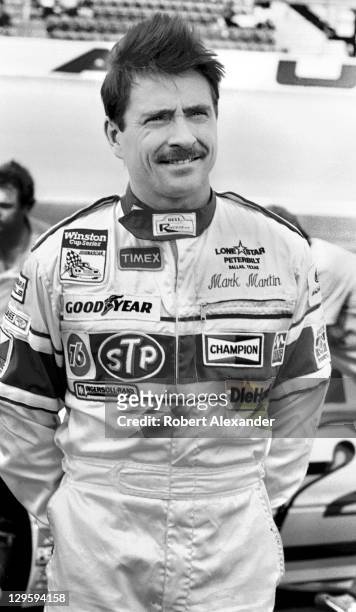 Driver Mark Martin stands next to his car during qualifying for the 1985 Daytona 500 on February 16, 1985 at the Daytona International Speedway in...