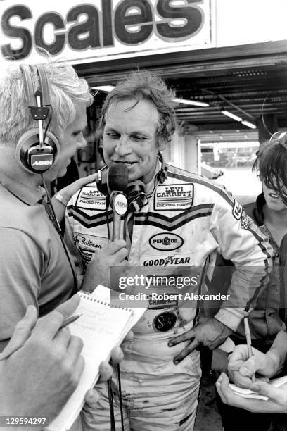 Driver Joe Ruttman talks with a Motor Racing Network radio broadcaster in the Daytona International Speedway garage area after the conclusion of the...