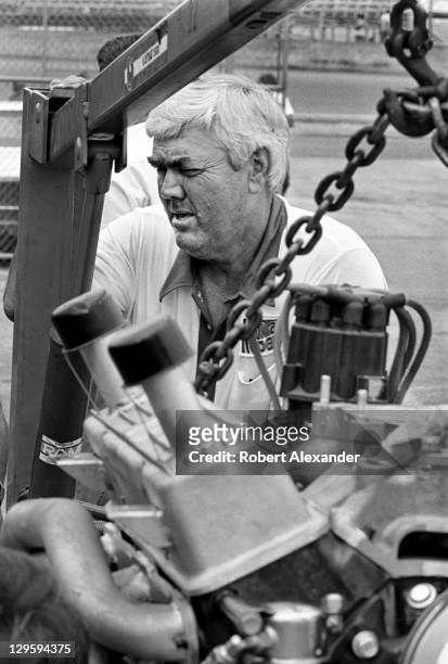 Race car owner Junior Johnson works on the engine of his No. 11 Budweiser car, driven by Darrell Waltrip, prior to qualifying for the 1982 Daytona...