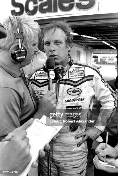 Driver Joe Ruttman talks with a Motor Racing Network radio broadcaster in the Daytona International Speedway garage area after the conclusion of the...