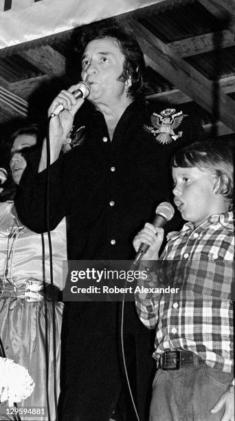 Johnny Cash performs at the A.P. Carter Memorial Festival in Maces Springs, Virginia. Performing with Cash is his wife, June Carter Cash and their...