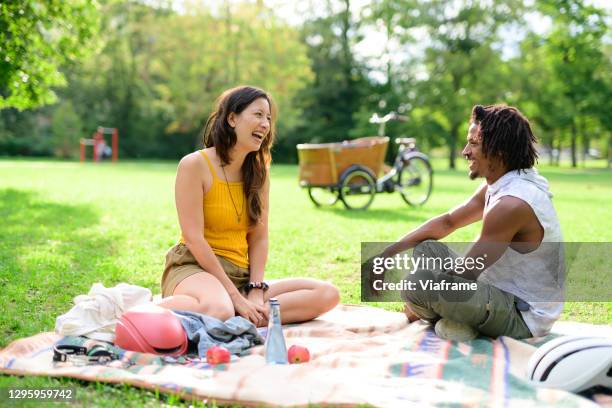 friends having a picnic in park - discussion germany outdoor friends stock-fotos und bilder