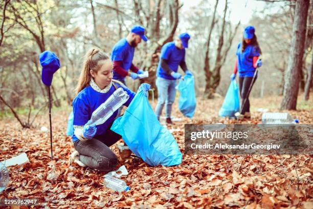 female picking up plastic bottles from forest - macedonia country stock pictures, royalty-free photos & images