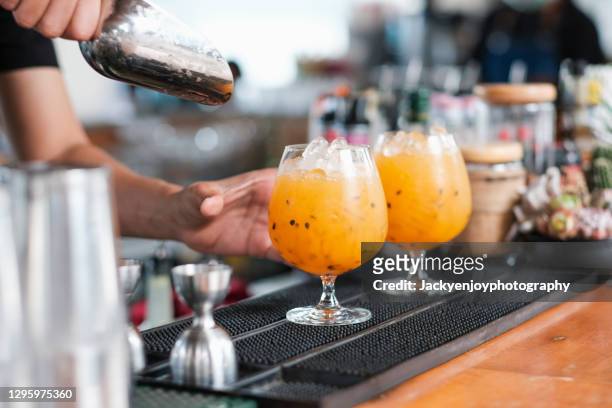 close up of freshly prepared cocktails in a row outdoors on a bar counter - cocktail counter stock-fotos und bilder