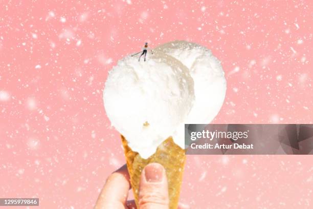 creative picture of skier figurine skiing in snowy ice cream cone during winter. - melting snowball stock pictures, royalty-free photos & images