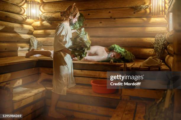 de mens is ontspannen bij russische sauna. badbegeleider serveert hem - banya stockfoto's en -beelden