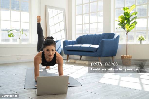 asian woman doing yoga video in home. - online yoga stock pictures, royalty-free photos & images