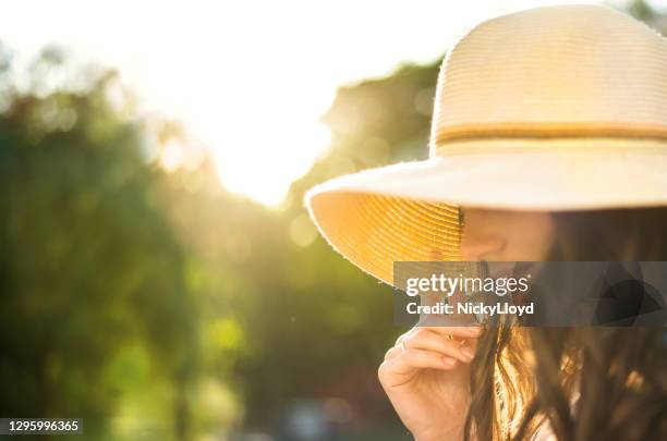 young woman in a sun hat standing outside on a sunny afternoon - wide brim stock pictures, royalty-free photos & images