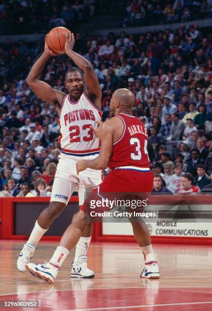 Mark Aguirre, Small Forward for the Detroit Pistons attempts a pass as Charles Barkley, Small Forward for the Philadelphia 76ers faces to block...