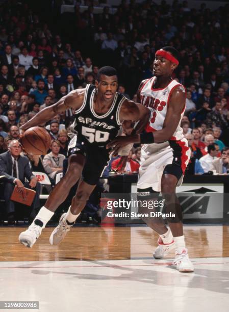 David Robinson, Center for the San Antonio Spurs dribbles the basketball around Clifford Robinson of the Portland Trail Blazers during their NBA...