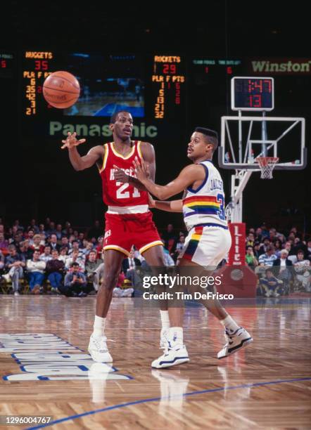 Mahmoud Abdul-Rauf, Point Guard for the Denver Nuggets looks on as Eric Sleepy Floyd, Point Guard and Shooting Guard for the Houston Rockets makes a...