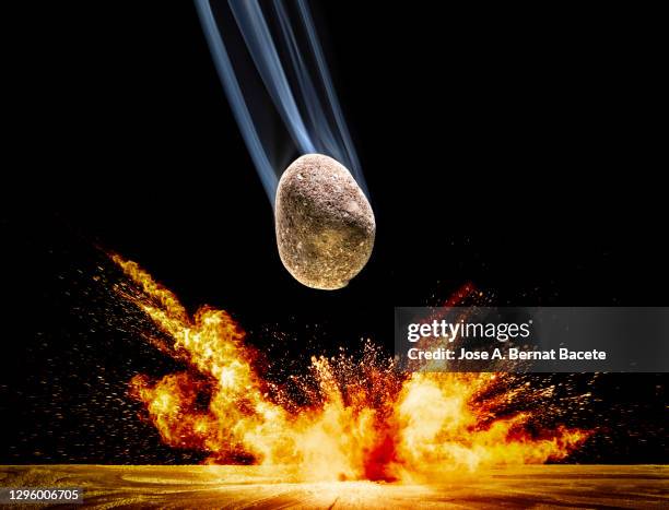 impact of meteorite, rock or stone of fire on the soil, producing an explosion and a crater of powder on a black background. - planets colliding stock pictures, royalty-free photos & images