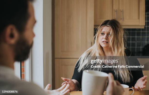 couple argue at a kitchen table - cross faded stock pictures, royalty-free photos & images