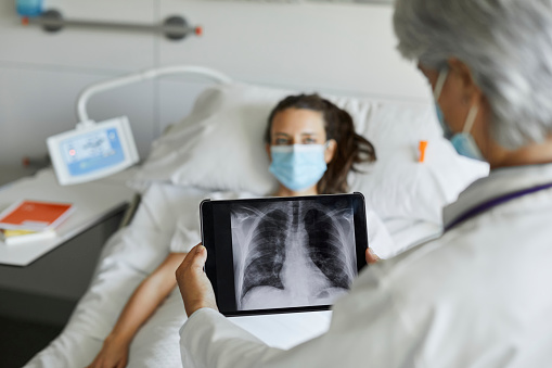 Doctor with digital x-ray by patient in ICU