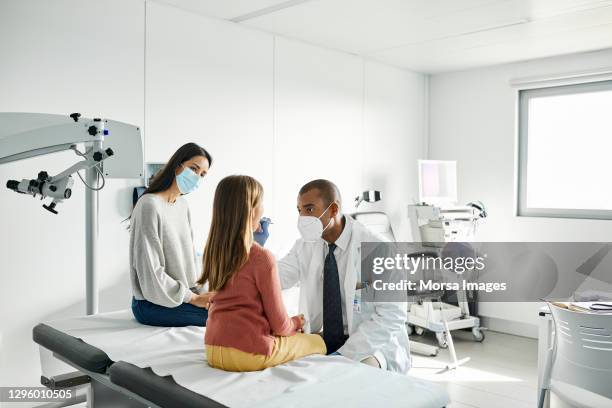 pediatrician taking swab test sample of girl - medical sample - fotografias e filmes do acervo