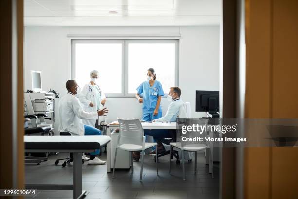 healthcare professionals discussing in hospital - infection prevention stockfoto's en -beelden