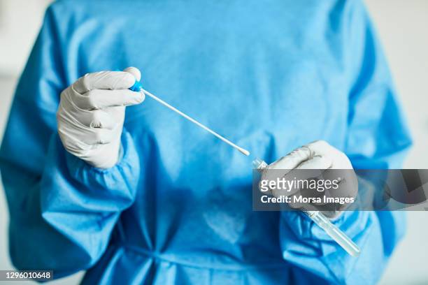 doctor/nurse with swab test sample in hospital, pcr device - coronavirus stock-fotos und bilder