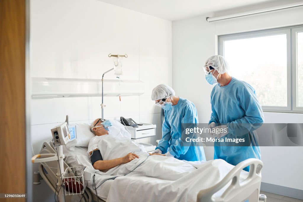 Doctors checking patient in ward during COVID-19