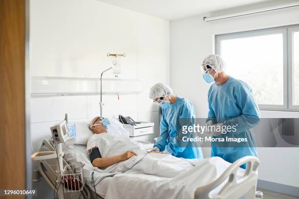 doctors checking patient in ward during covid-19 - ventilador equipo respiratorio fotografías e imágenes de stock