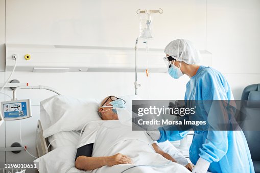 Doctor consoling patient in ICU during COVID-19 Doctor consoling patient in ICU during COVID-19