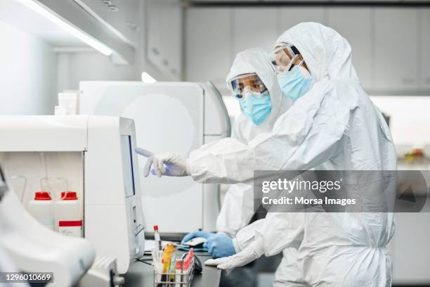 doctors working in laboratory during pandemic - protective suit stock pictures, royalty-free photos & images