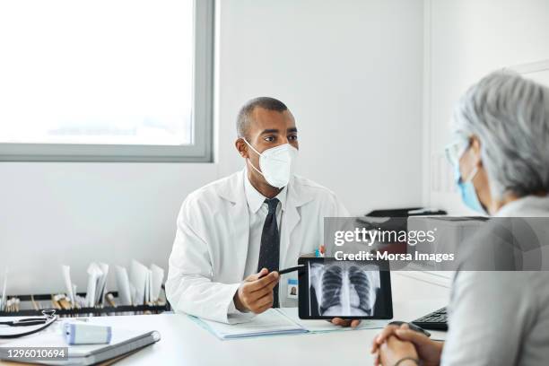 doctor explaining woman over tablet pc in hospital - ultrasonografia médica instrumento para diagnóstico - fotografias e filmes do acervo