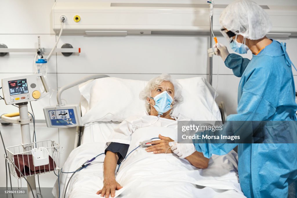 Doctor examining patient in ICU during COVID-19
