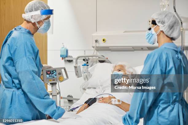 doctors examining woman in icu during covid-19 - person on ventilator stock pictures, royalty-free photos & images