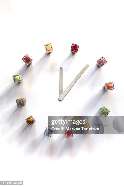 multi-colored nail polishes and nail files in the shape of a clock. - fingernail stock photos et images de collection