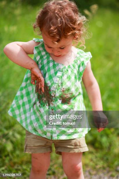 little girl with mud on her hands - girl wet casual clothing stock pictures, royalty-free photos & images