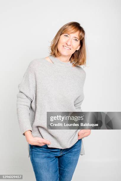 mature woman wearing denim in studio white background - man portrait full body 50's stock-fotos und bilder