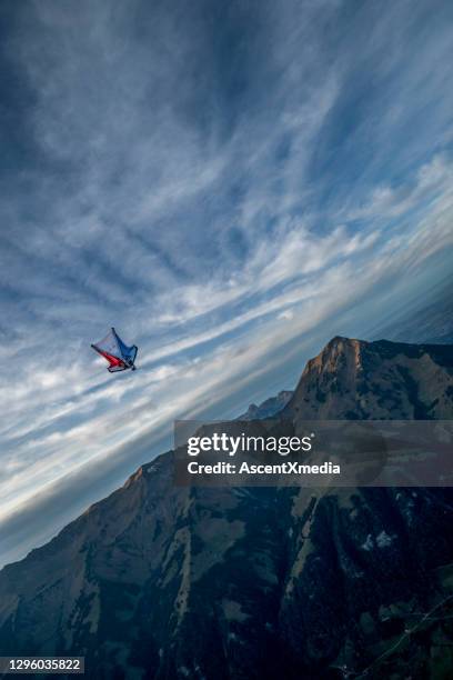 wing suit flier flies through clear skies in the morning - agile transformation stock pictures, royalty-free photos & images