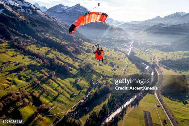 il parapendio vola attraverso cieli limpidi al mattino - paracadutista foto e immagini stock