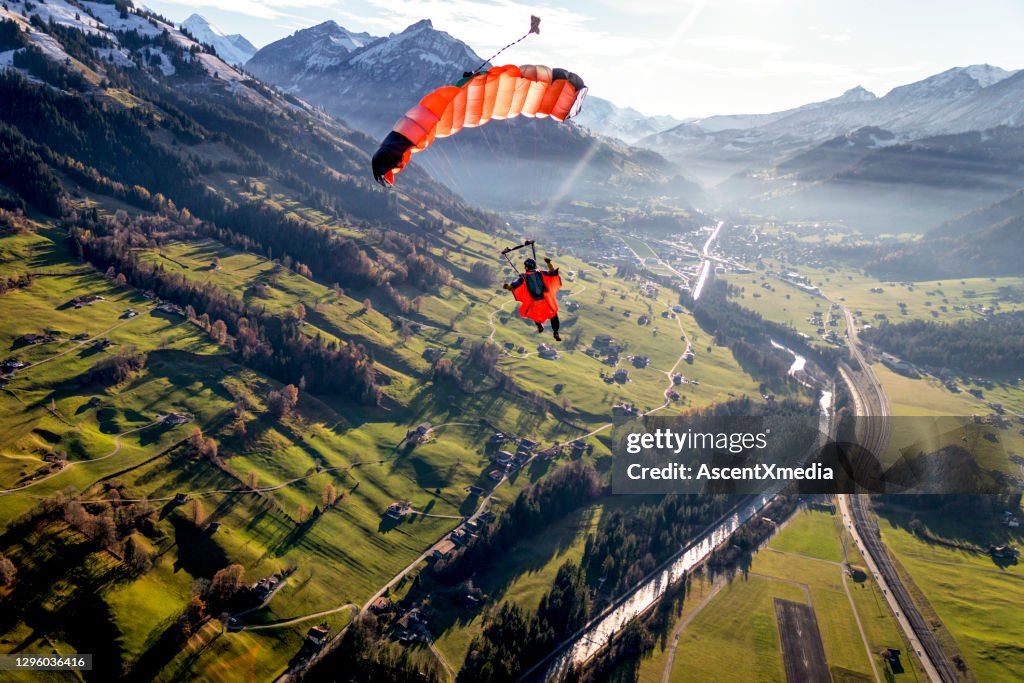 Paraglider flies through clear skies in the morning