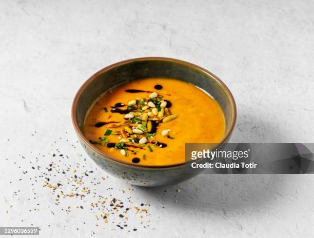 bowl of pumpkin soup on white background - soup stock pictures, royalty-free photos & images