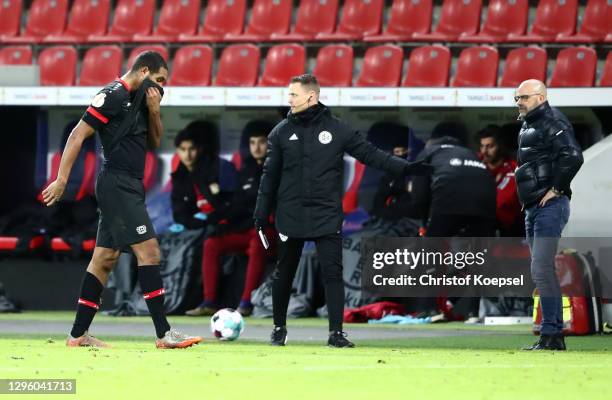 Jonathan Tah of Bayer Leverkusen walks off the pitch after being sent off as Peter Bosz, Head Coach of Bayer Leverkusen reacts during the DFB Cup...