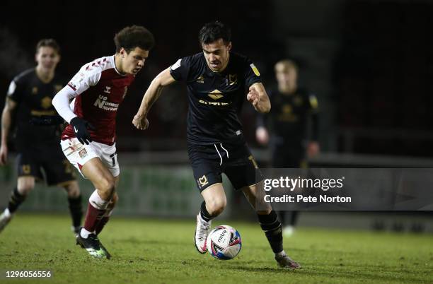 Scott Fraser of Milton Keynes Dons moves with the ball past Shaun McWilliams of Northampton Town during the Papa John's Trophy match between...