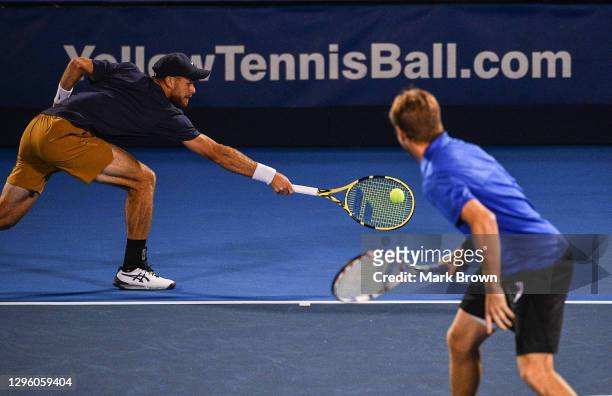 Christian Harrison returns a shot against Hugo Nys of Monaco and Andrés Molteni of Argentina while playing with his brother Ryan Harrison during the...
