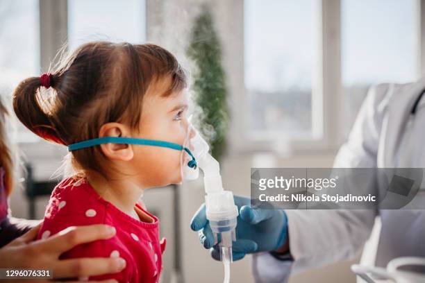 asthma, little girl with inhaling mask - bronchus stock pictures, royalty-free photos & images