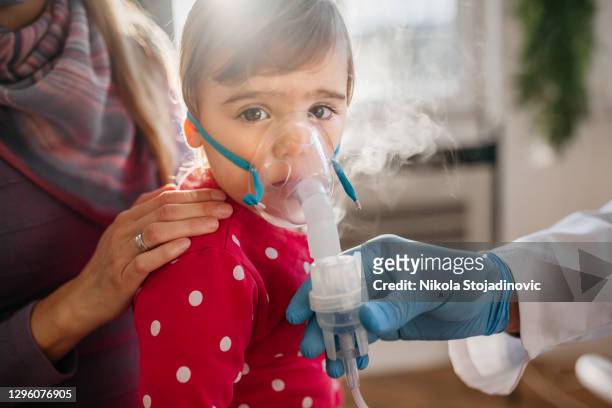 asthma, little girl with inhaling mask - respiratory disease stock pictures, royalty-free photos & images