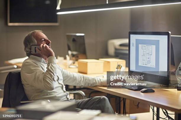 male architect in mid 50s using phone in modern office - project manager stock pictures, royalty-free photos & images